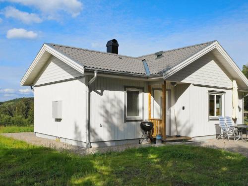 a white house with a porch and a lawn at 5 person holiday home in LJUNGSKILE in Ljungskile