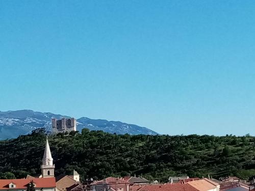 a view of a city with a church on a hill at Apartman Petra in Senj
