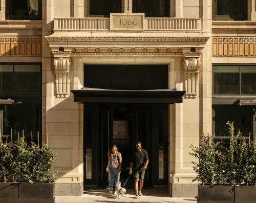 two people walking down a sidewalk in front of a building at The Hoxton, Downtown LA in Los Angeles