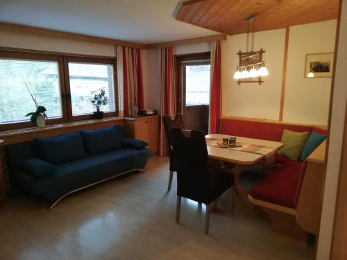 - un salon avec un canapé bleu et une table dans l'établissement Haus Rainer, à Matrei in Osttirol