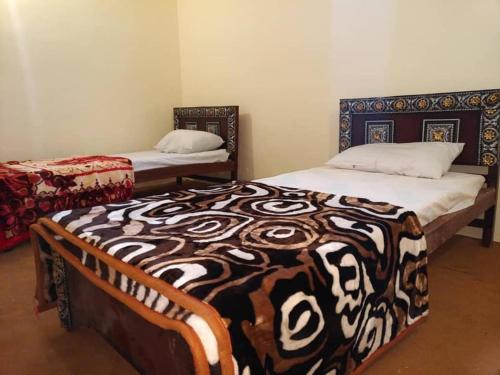 sypialnia z 2 łóżkami i kocem w obiekcie Guest House De Grand Imperial w mieście Hunza