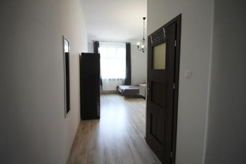 a hallway with a door and a room with a couch at Ali 2 in Sosnowiec