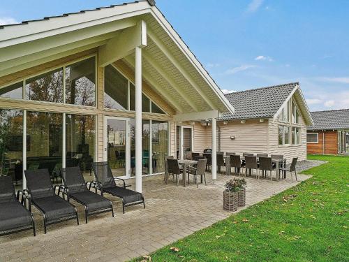 a patio with chairs and tables on a house at 18 person holiday home in Hasselberg in Kappeln