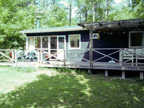 a blue tiny house with a porch in the woods at 4 person holiday home in Silkeborg in Silkeborg