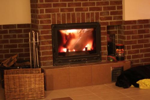 a fireplace with a television in a brick wall at Siwejka - Ropki - Beskid Niski in Ropki