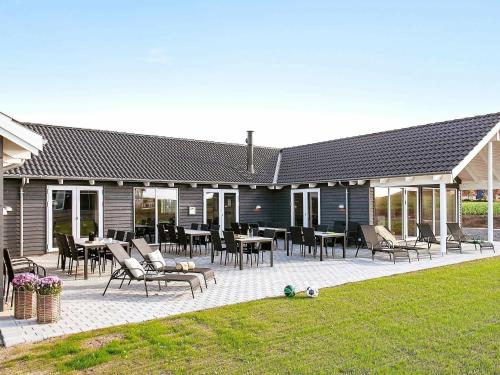 un patio con sillas y mesas en una casa en 30 person holiday home in Bogense, en Bogense
