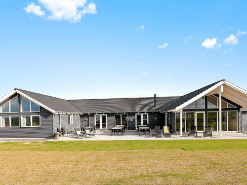 ボーゲンセにある30 person holiday home in Bogenseの大きなポーチとパティオ付きの大きな家