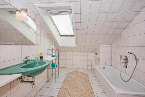 a bathroom with a green sink and a bath tub at An den beiden Krebsseen - Ferienhäuser-Wohnungen in Bansin