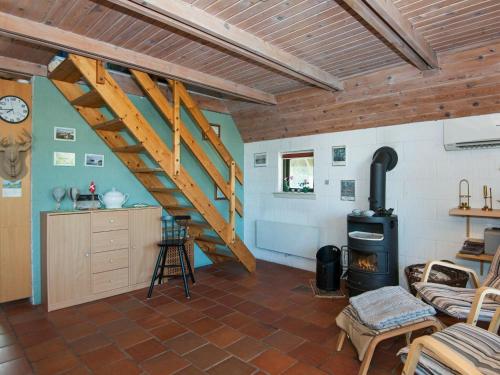 a living room with a staircase and a stove at 8 person holiday home in Glesborg in Fjellerup