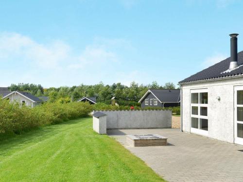 a backyard of a white house with a lawn at 6 person holiday home in Hemmet in Hemmet