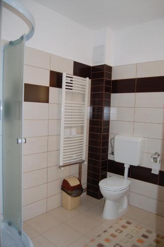 a bathroom with a toilet and black and white tiles at Pensiunea Sarah Bran in Bran