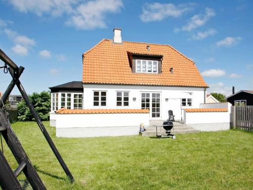 uma casa branca com um telhado laranja em 8 person holiday home in L kken em Løkken