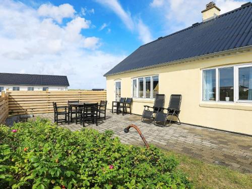 a patio with a table and chairs and a house at 6 person holiday home in Harbo re in Harboør