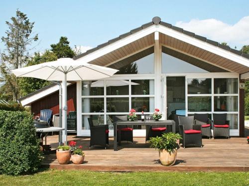 um pavilhão com uma mesa e um guarda-chuva em 6 person holiday home in Dannemare em Dannemare