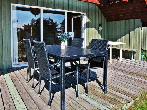 a black dining table and chairs on a deck at 6 person holiday home in Hvide Sande in Hvide Sande