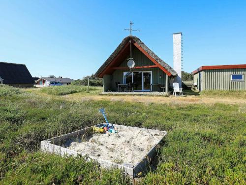 a church with a sandbox in front of a building at 6 person holiday home in Hvide Sande in Hvide Sande