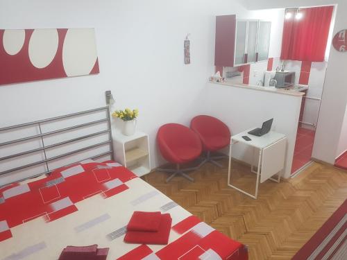 1 dormitorio con 1 cama y 2 sillas rojas en Calea Victoriei Residence, en Bucarest