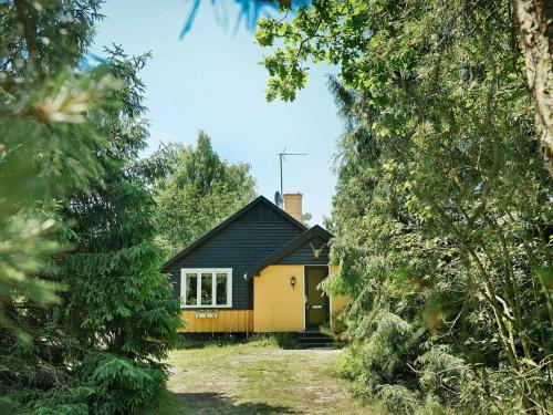 Balkeにある4 person holiday home in Nexの木々から黄色い家が見える