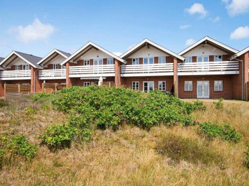 Une rangée de maisons sur une colline avec de l'herbe dans l'établissement 4 person holiday home in R m, à Rømø Kirkeby