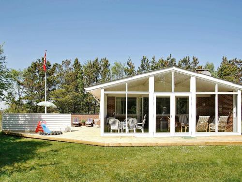 a conservatory with chairs and tables on a deck at 6 person holiday home in Jerup in Jerup