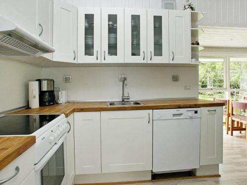 een keuken met witte kasten en een wastafel bij 6 person holiday home in lb k in Ålbæk