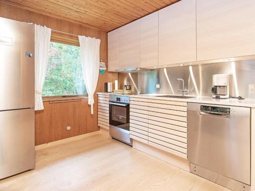 d'une cuisine équipée d'appareils en acier inoxydable et d'une fenêtre. dans l'établissement 6 person holiday home in L s, à Læsø