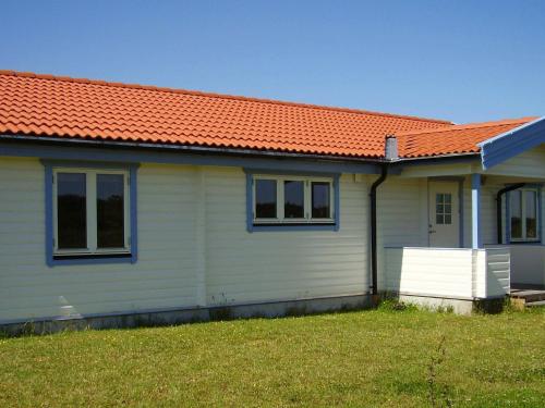 a small white house with an orange roof at 6 person holiday home in R dby in Kramnitse