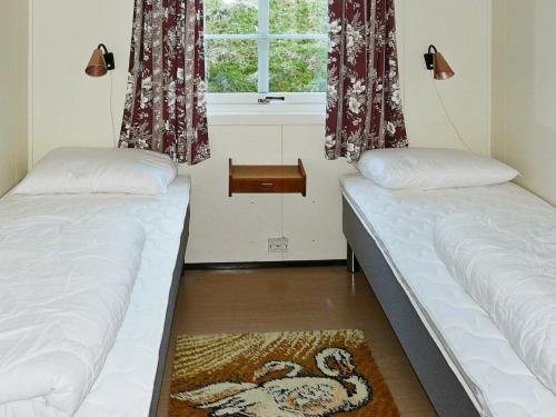 two beds in a room with a window at 4 person holiday home in Lauvstad-By Traum in Lauvstad