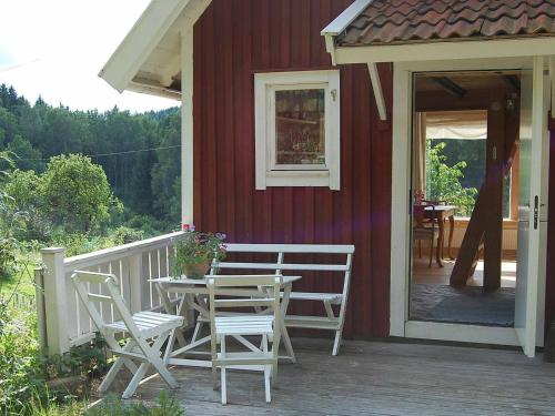 a porch of a red house with a table and chairs at 5 person holiday home in FLODA in Floda