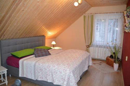 sypialnia z łóżkiem i drewnianym sufitem w obiekcie Ferienhaus Linde am Bleßberg w mieście Schirnrod