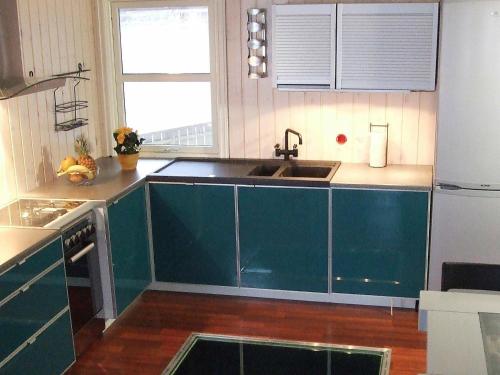 a kitchen with green cabinets and a sink at 8 person holiday home in Kalvåg-By Traum in Kalvåg