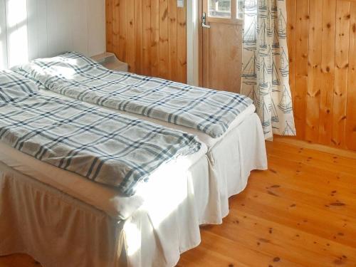 uma cama com um cobertor azul e branco em Holiday Home Rensvikholmen em Frei