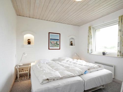 ホにあるFive-Bedroom Holiday home in Blåvand 29の白いベッドルーム(白いシーツを使用した大型ベッド1台付)