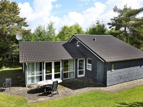 una pequeña casa negra con mesa y sillas en 8 person holiday home in lb k, en Bunken