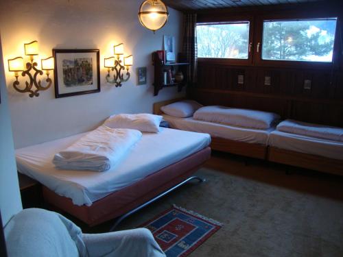 a room with two beds and a couch and two windows at Appartement am Lift in Saalbach-Hinterglemm