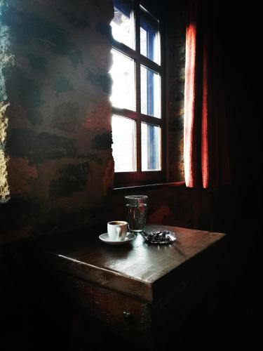 a table with a cup of coffee and a window at Villa Vadola in Arkochórion