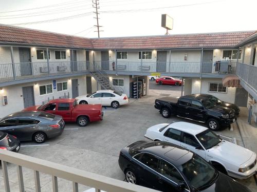 a parking lot with cars parked in front of a building at Golden West Manor Motel in Los Angeles
