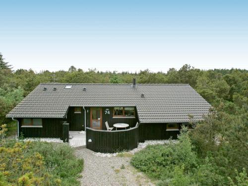 een zwart huis met een tafel ervoor bij 8 person holiday home in Fjerritslev in Torup Strand