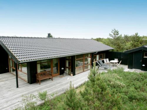 una casa con una terraza de madera frente a ella en 8 person holiday home in Fjerritslev, en Torup Strand