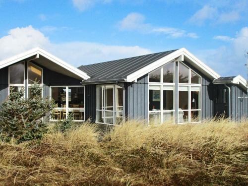 a house with a black roof and windows at 10 person holiday home in Harbo re in Harboør