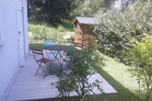 un patio con mesa y sillas y una casa de aves en Les Echappées Belles - Studio entre océan et forêt, en Tarnos