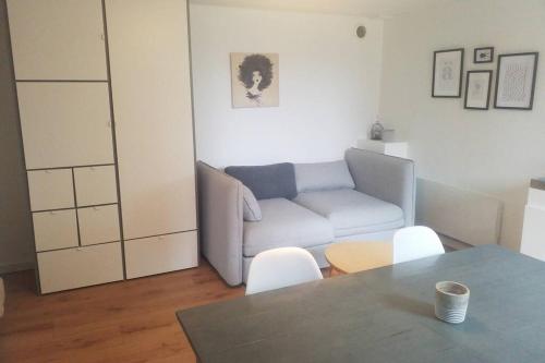 a living room with a couch and a table at Les Echappées Belles - Studio entre océan et forêt in Labenne