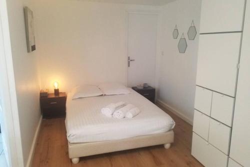 a small bedroom with a white bed with two pillows at Les Echappées Belles - Studio entre océan et forêt in Labenne