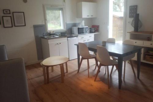 cocina con mesa y sillas y comedor en Les Echappées Belles - Studio entre océan et forêt, en Tarnos