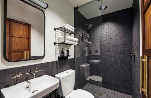 a bathroom with a toilet and a sink and a mirror at The Hoxton, Portland in Portland