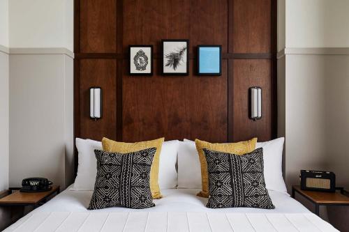 a bedroom with a white bed with a wooden headboard at The Hoxton, Portland in Portland