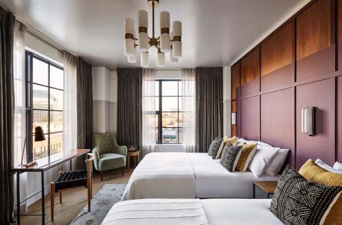 ポートランドにあるThe Hoxton, Portlandのベッド2台とシャンデリアが備わるホテルルームです。