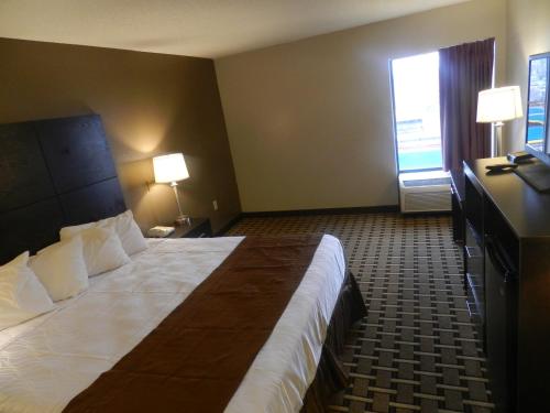 a hotel room with a large bed and a window at Haven Inn & Suites in Duluth