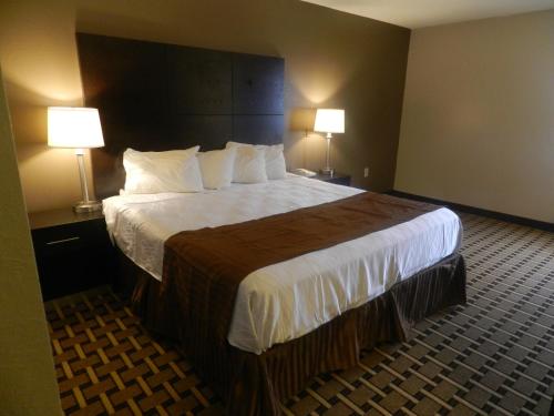 a hotel room with a large bed with two lamps at Haven Inn & Suites in Duluth
