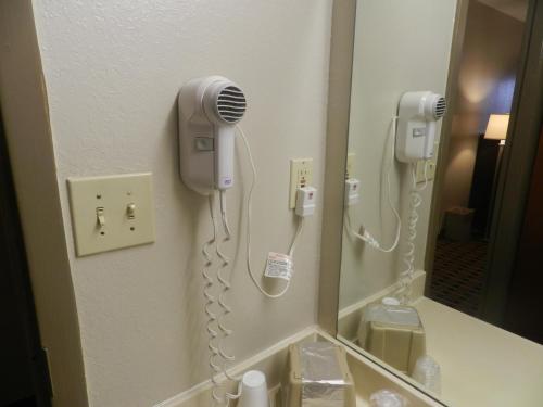 a bathroom with a hair dryer and a mirror at Haven Inn & Suites in Duluth